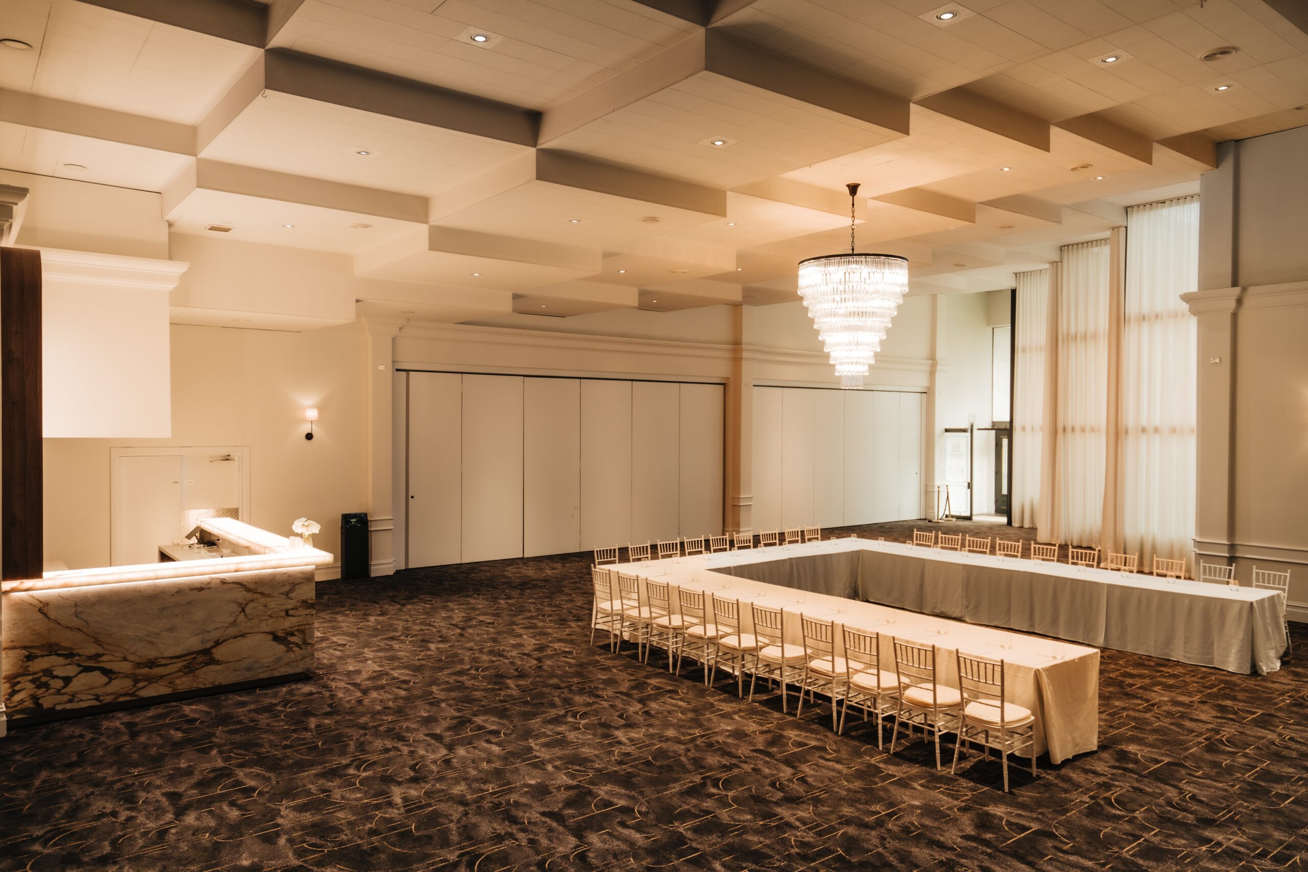 Magnolia room with u shape table, chandelier and warm lighting