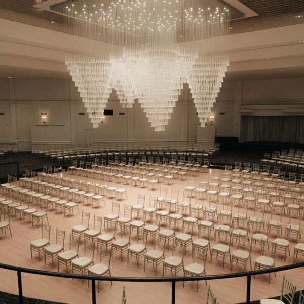 The grand ballroom with hundreds of seats set-up sitting under a chandelier, ready for an event