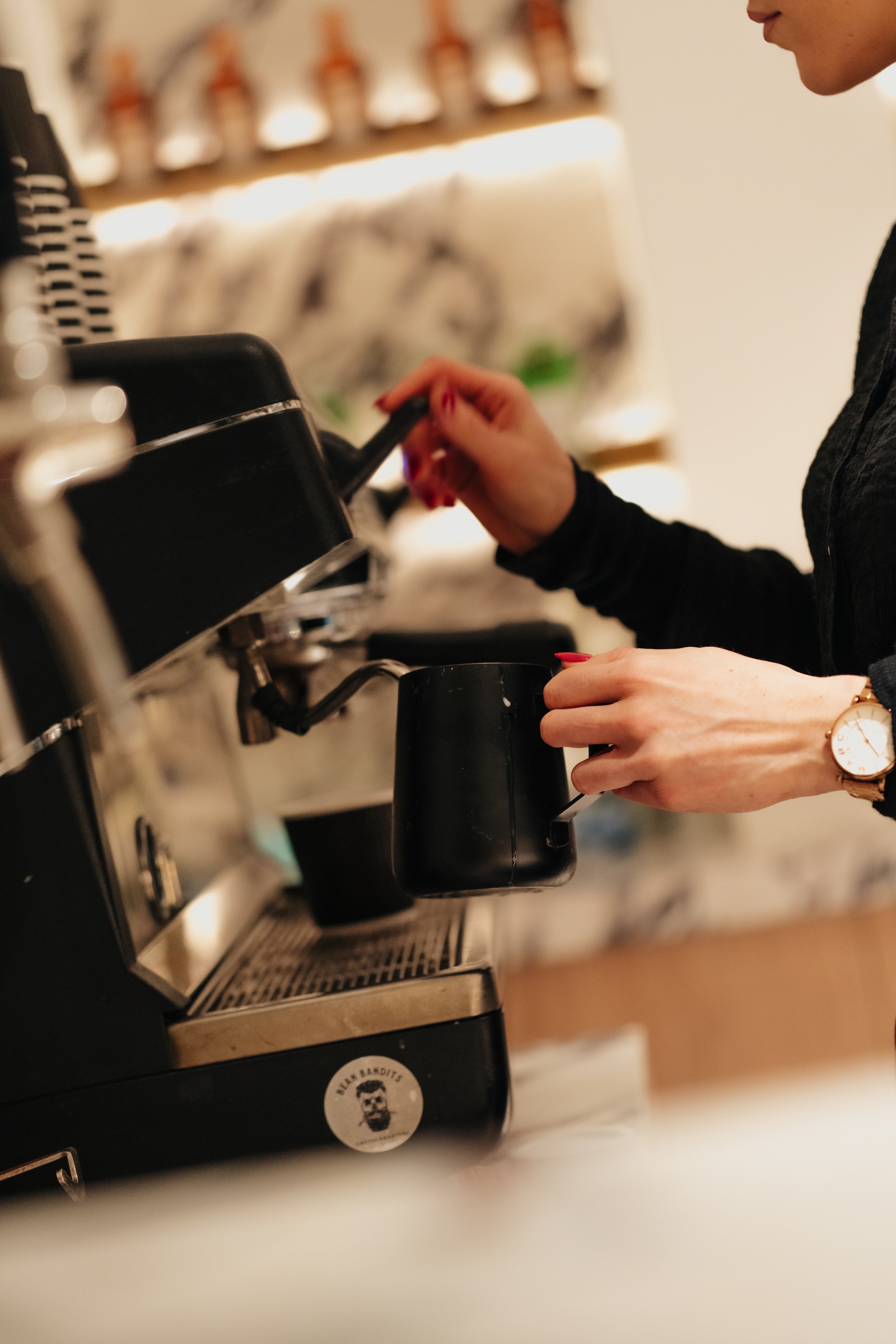 Barista preparing coffee at the espresso machine against a marble wall