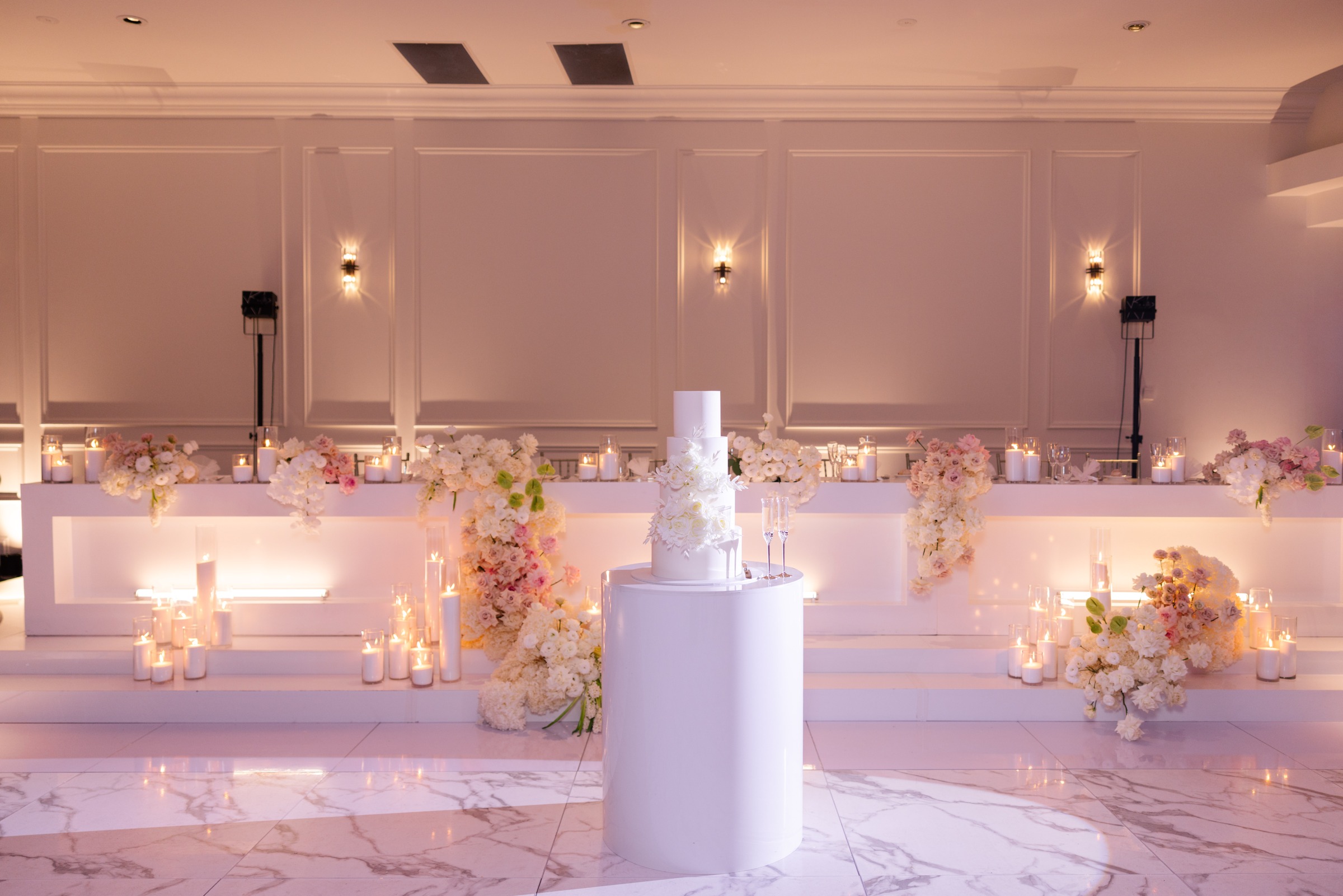 White wedding cake and floral bridal table in the Melrose reception room