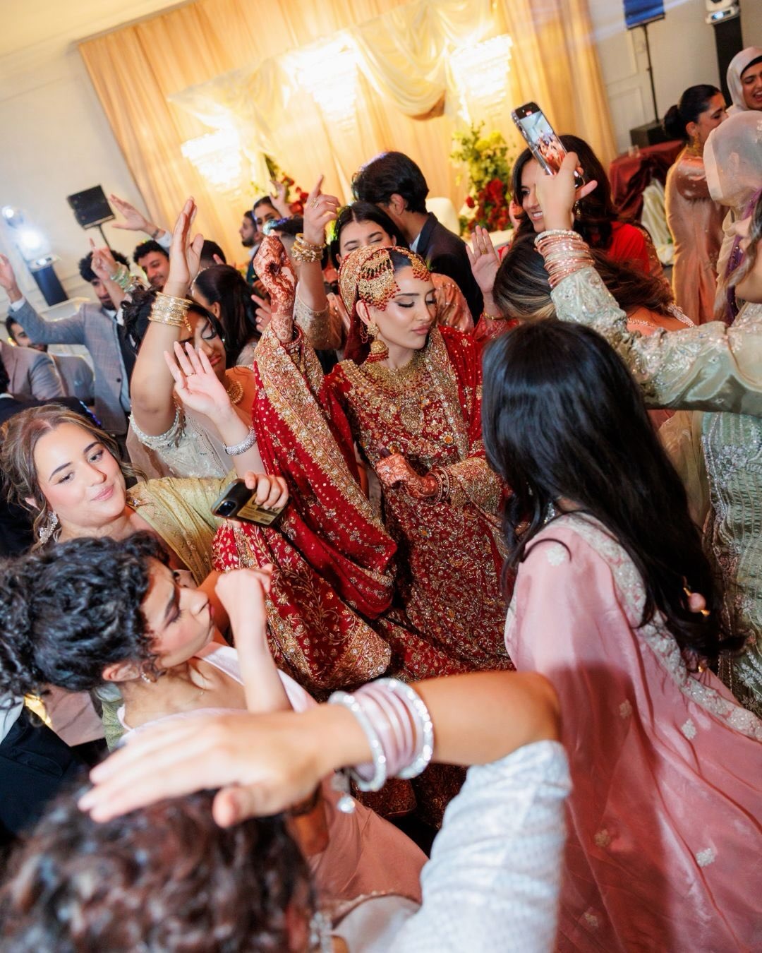 Bride in red surrounded by guests celebrating at a cultural wedding at Melrose Events