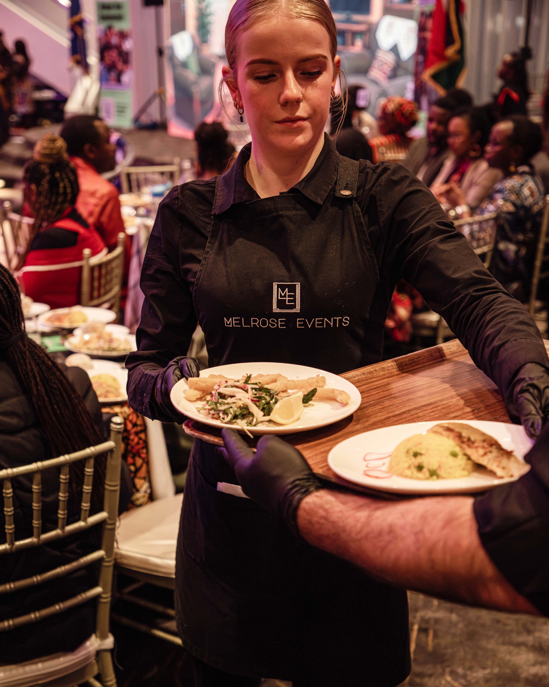 Melrose Events wait staff serving plated dishes to seated guests