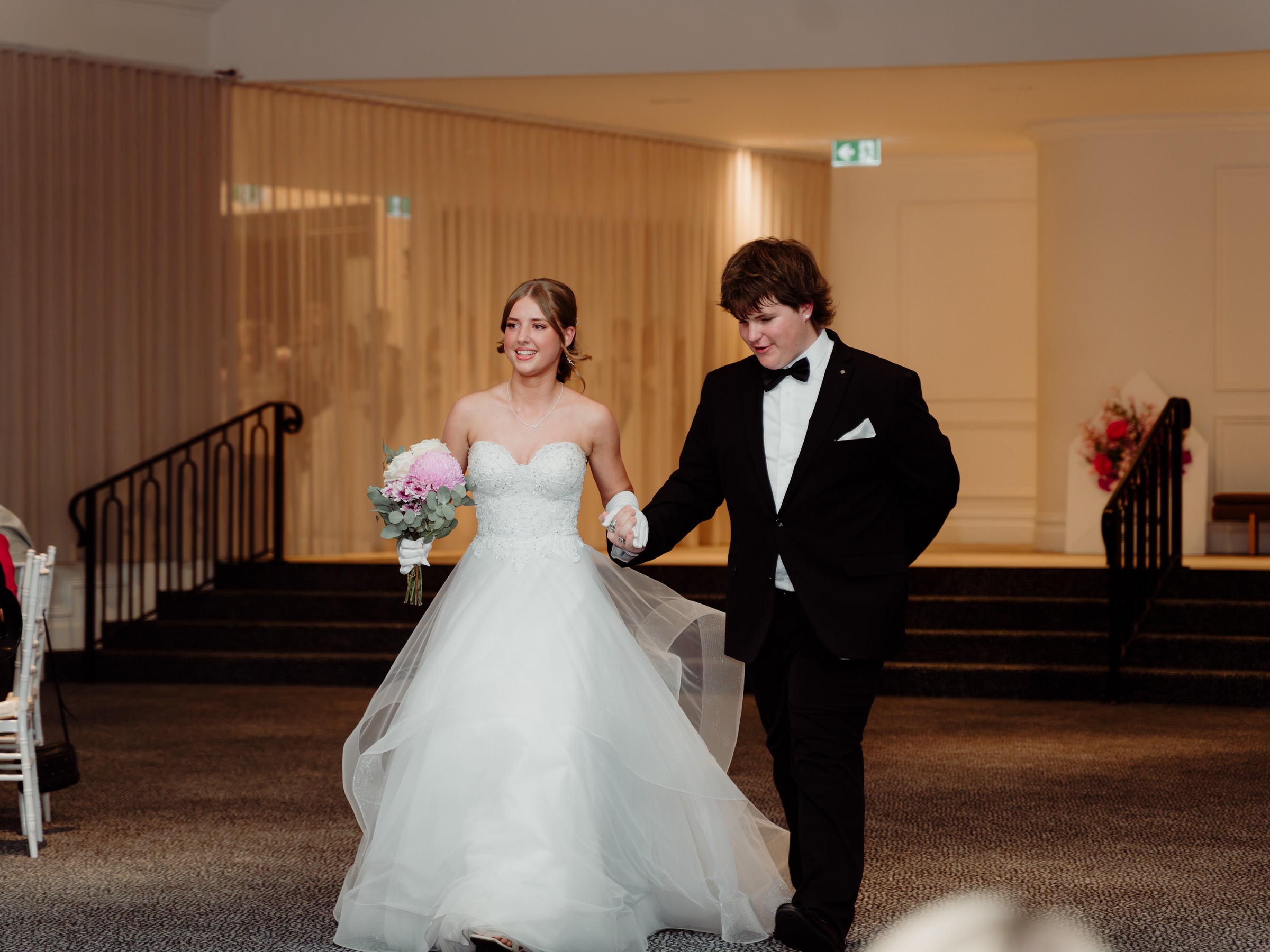 Debutante and her partner arriving hand in hand at the foot of the Melrose staircase