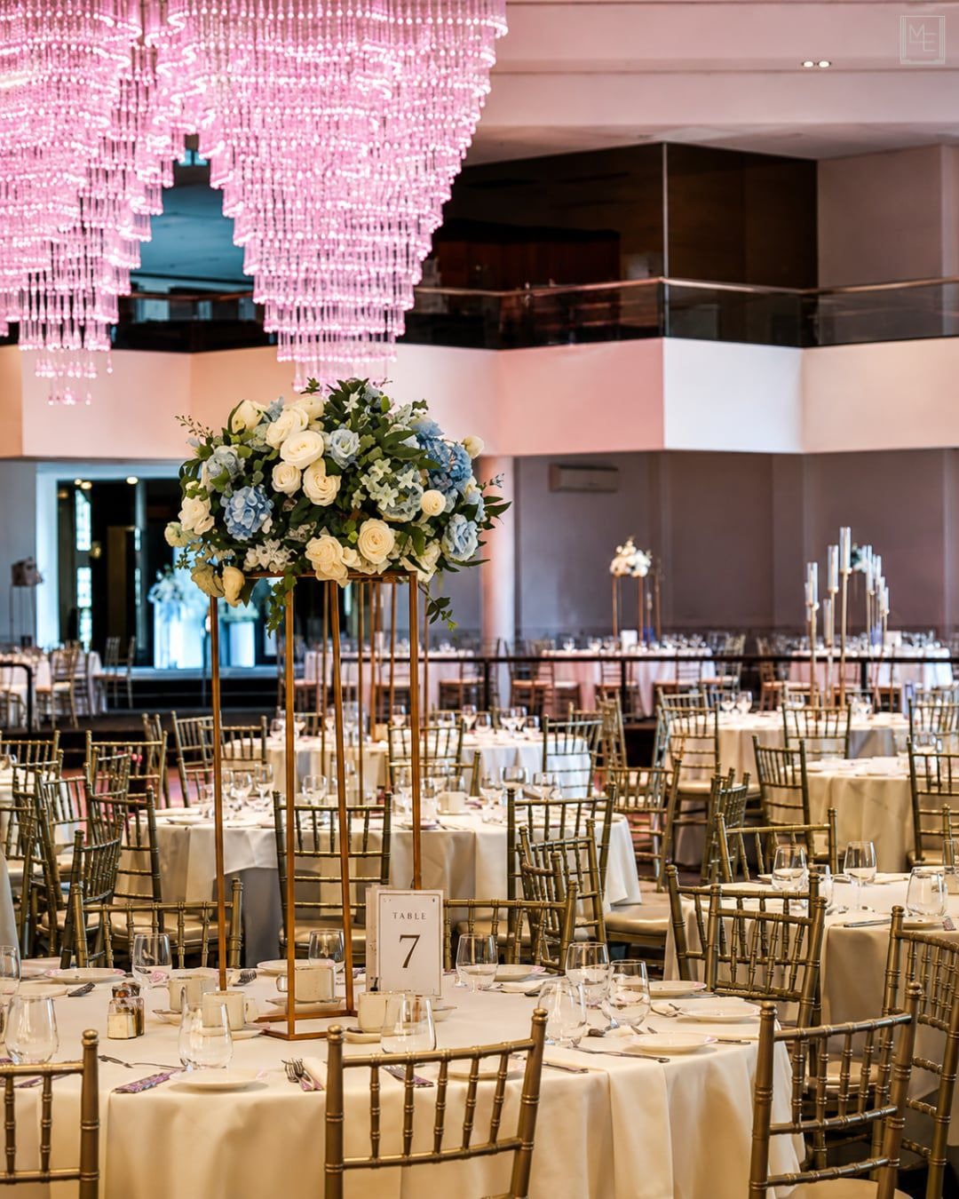 Tall floral centrepieces on gold stands at an engagement party at Melrose Events