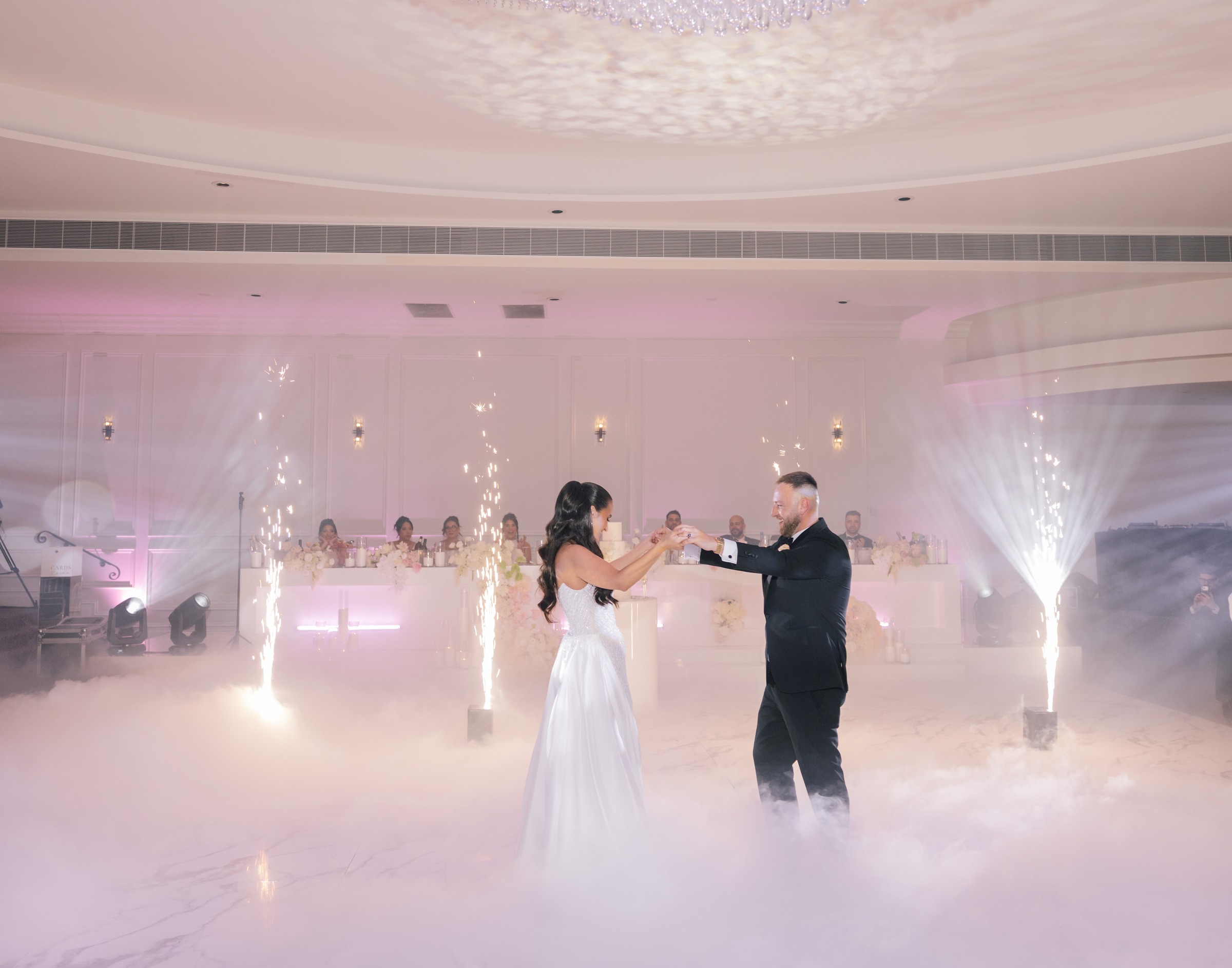 Couple's first dance on a fog-covered floor with sparkler fountains