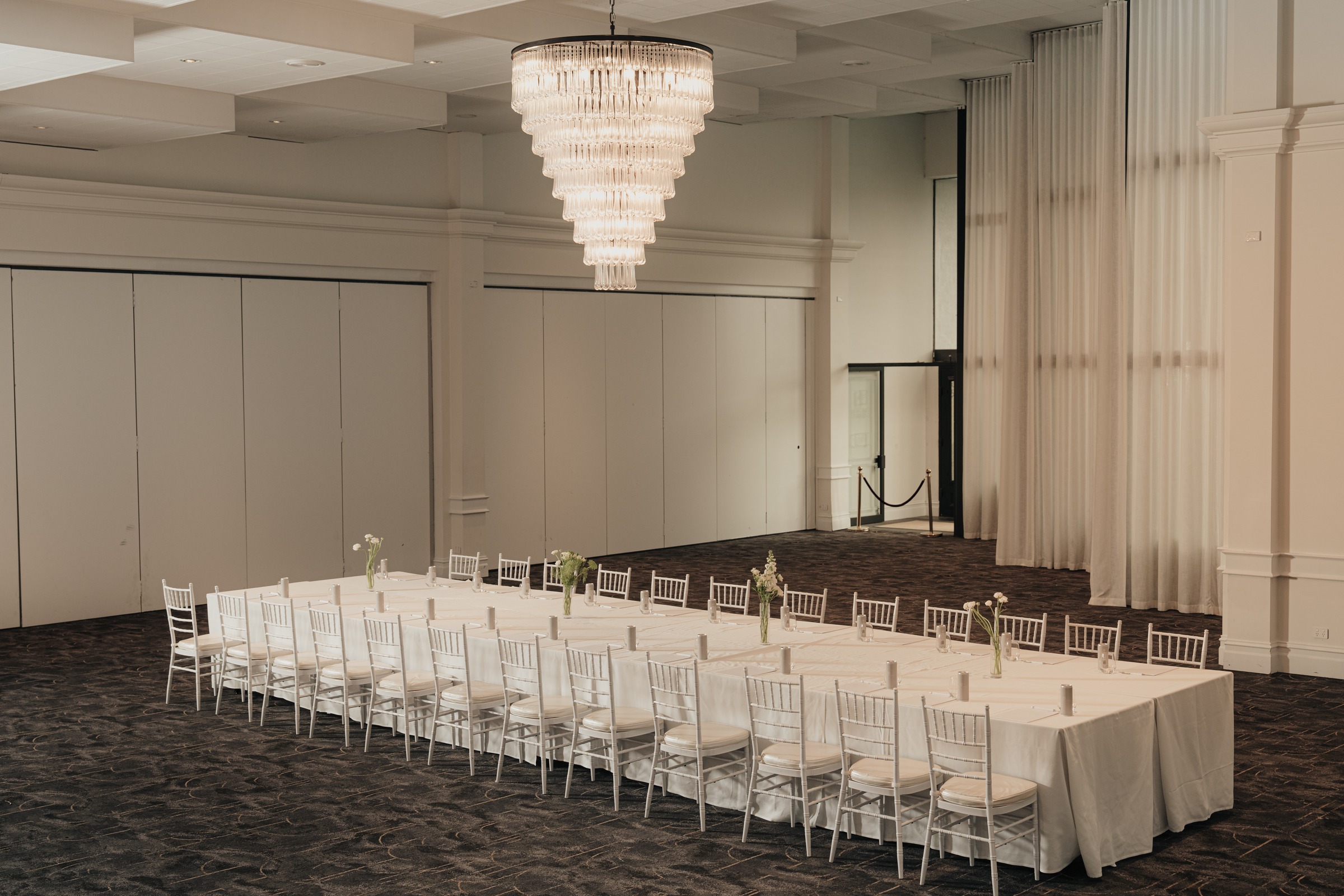 Magnolia Room with two long tables in soft daylight from the sheer curtains