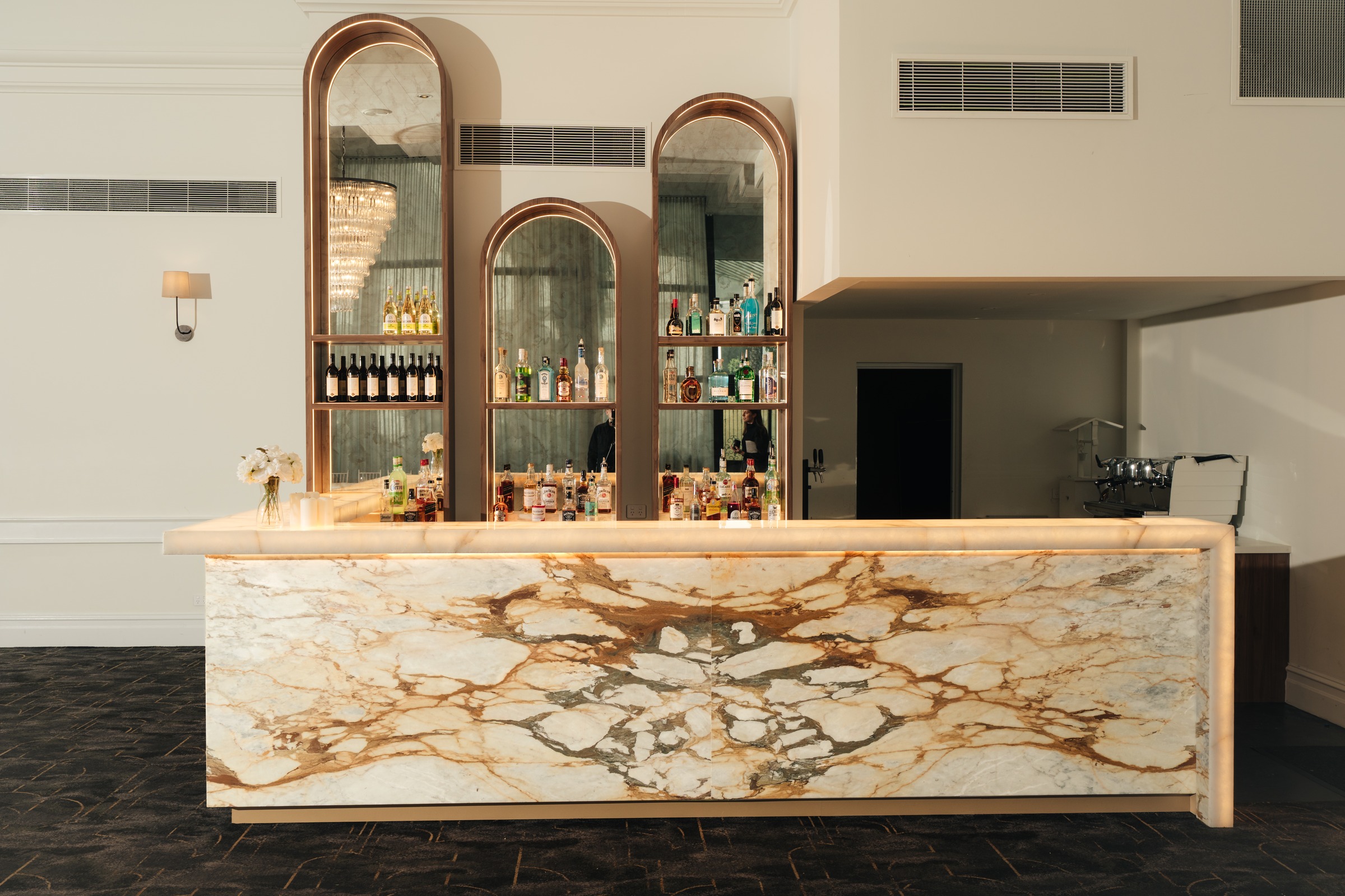 Marble bar with arched mirrors and back-bar shelving in the Magnolia Room at Melrose Events