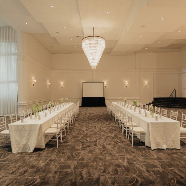 Magnolia Room at Melrose Events with long banquet tables under the chandelier