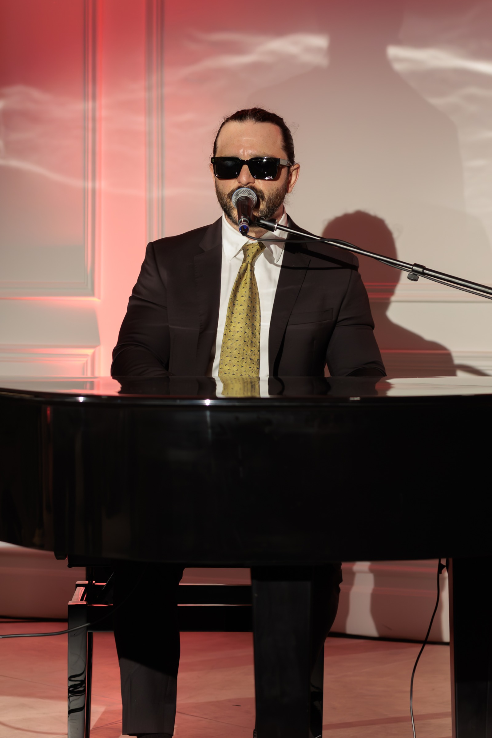 Live pianist performing at a grand piano with a microphone at Melrose