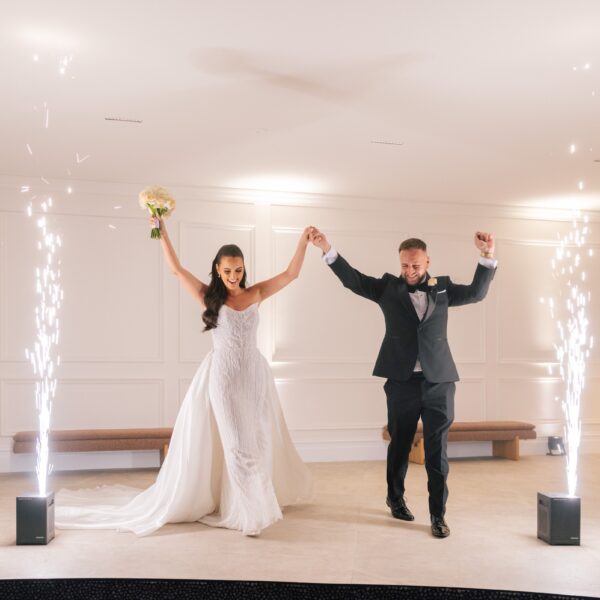 Bride and groom making their entrance between cold spark fountains
