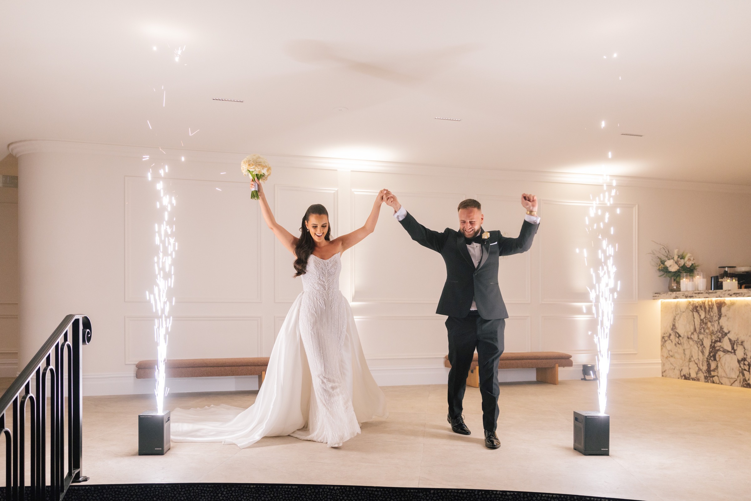 Bride and groom making their entrance between cold spark fountains